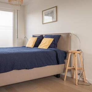 um quarto com uma cama com almofadas azuis e amarelas em Gasthuis 20 verdiep 2 em Kuurne