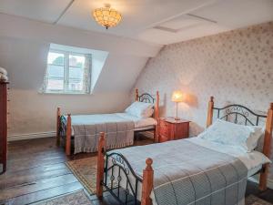 a bedroom with two beds and a window at Ellinor House in Cleobury Mortimer