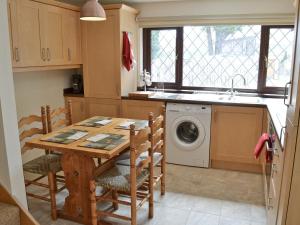 a kitchen with a table and a washing machine at Invergarry in Carlyon Bay