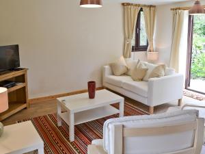 a living room with a white couch and a tv at Invergarry in Carlyon Bay