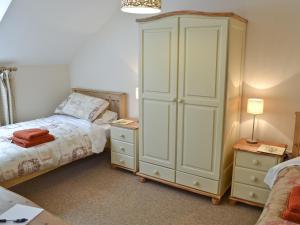 a bedroom with a large white cabinet next to a bed at Invergarry in Carlyon Bay