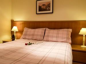 ein Schlafzimmer mit einem Bett mit einer Blume darauf in der Unterkunft The Bothy in Glendevon