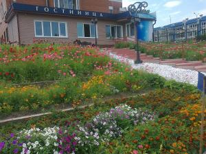 a garden of flowers in front of a building at Vega Hotel in Irkutsk