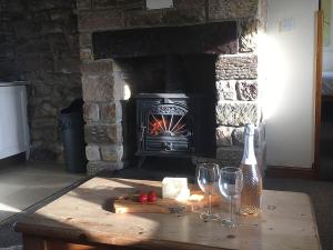 a table with wine glasses and a fireplace at Boothferry - 18425 in Rosedale Abbey