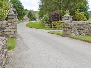 a dirt road with a stone fence and a gate at Boothferry - 18425 in Rosedale Abbey