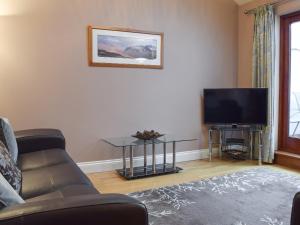 a living room with a couch and a flat screen tv at The Old Laundry 1 in Keswick