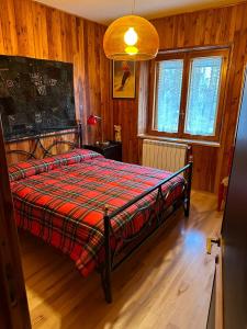 a bedroom with a bed in a room with wooden walls at Appartamento incantevole e confortevole con Camino in Terminillo