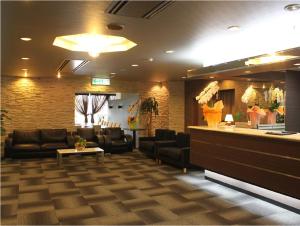 a waiting room with couches and a bar at HOTEL LiVEMAX BUDGET Iyo Mishima in Shikokuchuo