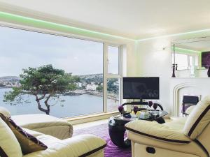 a living room with a large window with a view at Riviera Mews in Torquay