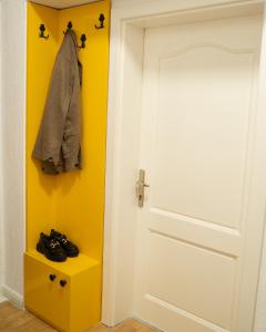 een kamer met een witte deur en een gele muur bij City Block Apartment in Pristina