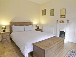 a bedroom with a large white bed and two lamps at The Dell in Fort Augustus