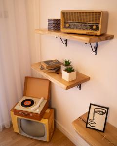 een kamer met een radio en een tv aan de muur bij City Block Apartment in Pristina