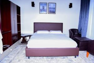 1 dormitorio con 1 cama grande y 1 silla en Enaiteru, en Oyugis