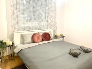 a white bed with two red pillows on it at Fun house in Zebanec-Selo