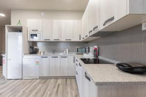 a kitchen with white cabinets and a white refrigerator at Erretola - Baskey Rentals in Aizarnazábal