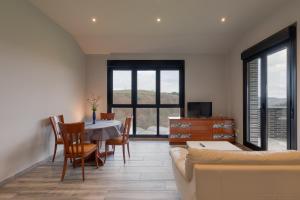 Una sala de estar con una mesa y sillas y un sofá. en Erretola - Baskey Rentals, en Aizarnazábal