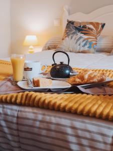 a breakfast tray with a tea kettle on a bed at Apartamento SOFIA in Tordesillas