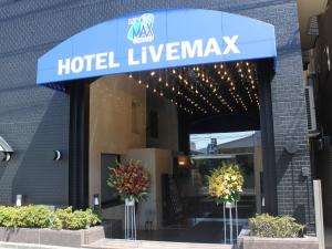 un signo de Livermark de hotel en la parte delantera de un edificio en HOTEL LiVEMAX BUDGET Tokyo Hamura Ekimae en Hamura