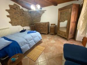 a bedroom with a bed and a stone wall at Casa Vacanze Maja e Ermes in Arsita