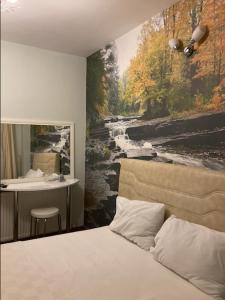um quarto com uma cama e uma pintura de um rio em Ağva Kapım Otel em Şile