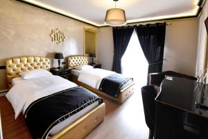 una camera d'albergo con due letti e una finestra di Hotel Hymeti's Palace a Pogradec