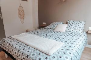 a bedroom with a bed with a blue and white comforter at Le petit rempart - Appt lumineux 2pers au coeur de Blois in Blois