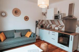 ein Wohnzimmer mit einem Sofa und einer Küche in der Unterkunft Le petit rempart - Appt lumineux 2pers au coeur de Blois in Blois