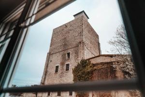 una ventana con vistas a una torre de ladrillo alta en Le petit rempart - Appt lumineux 2pers au coeur de Blois, en Blois