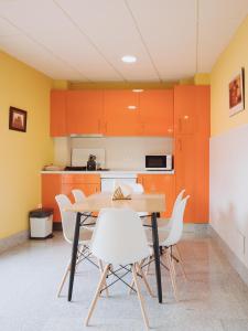 una cocina con armarios naranjas y una mesa y sillas de madera. en Apartamento "CAMPO CARMEN", en Tordesillas