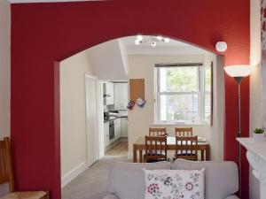 ein Wohnzimmer mit einer Wand mit roten Akzenten in der Unterkunft Millies Cottage in Keswick