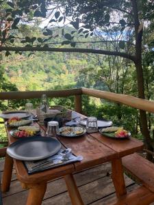 einem Holztisch mit Teller mit Lebensmitteln darauf in der Unterkunft Ella Retreat Glamping Bell Tent For Nature Lovers in Ella