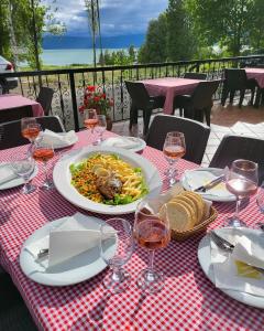 een tafel met een bord eten en wijnglazen bij Mayberry Lake - Villa Medijapark in Pretor