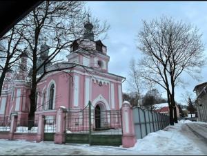 a pink building with a fence in front of it at Delta 8 - two big beds in Tartu