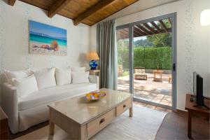 ein Wohnzimmer mit einem weißen Sofa und einem Tisch in der Unterkunft Dionysos Hotel in Ixia