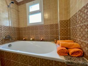 a bathroom with a tub with towels and a window at Magnifique villa - 5 chambres - Ifrane in Ifrane