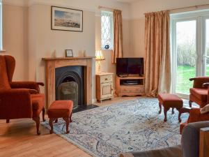 a living room with a fireplace and a tv at The Glade in Ferring