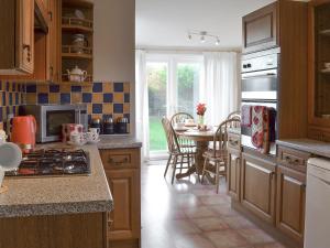 a kitchen with a table and a dining room at The Glade in Ferring