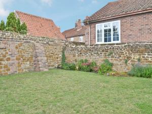 a brick wall in front of a house at Sweet Pea Cottage in Heacham