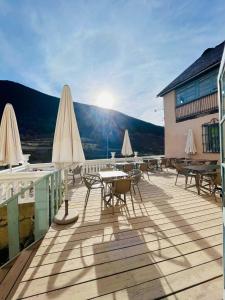 una terraza con mesas y sillas en un edificio en Hostel Baqueira - Refugi Rosta - PyrenMuseu, en Salardú