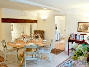 a dining room with a wooden table and chairs at Riverside Cottage in Washford
