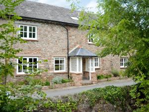 an old brick house with white windows and a driveway at Riverside Cottage in Washford