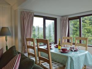 a dining room table with chairs and a blue table cloth at Log Cabin in Lamphey