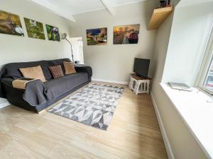 ein Wohnzimmer mit einem Sofa und einem TV in der Unterkunft Dragonfly One in North Newton