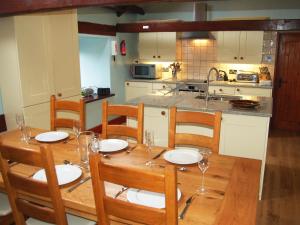 a kitchen with a wooden table with chairs and a dining room at Gill Barn in Bampton