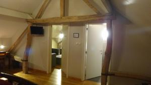 an attic room with a door leading to a bedroom at Rikkeshoeve vakantiewoning in Sint-Truiden