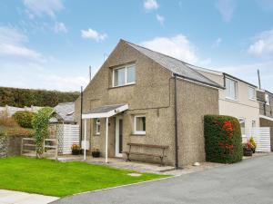 a brick house with a bench in a yard at Fron Erch Cottages - 2711 in Llanarmon