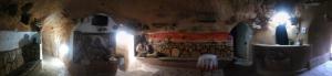 Touring Club MARHALA MATMATA في Matmata: غرفة بها جدار وبه لوحات