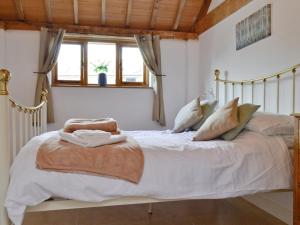 Schlafzimmer mit einem Bett mit weißer Bettwäsche und Kissen in der Unterkunft The Parlour in Arlingham