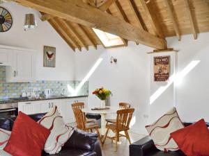 a kitchen and living room with a table and chairs at The Parlour in Arlingham
