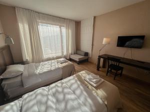 a hotel room with two beds and a desk at Hotel Truso in Gudauri